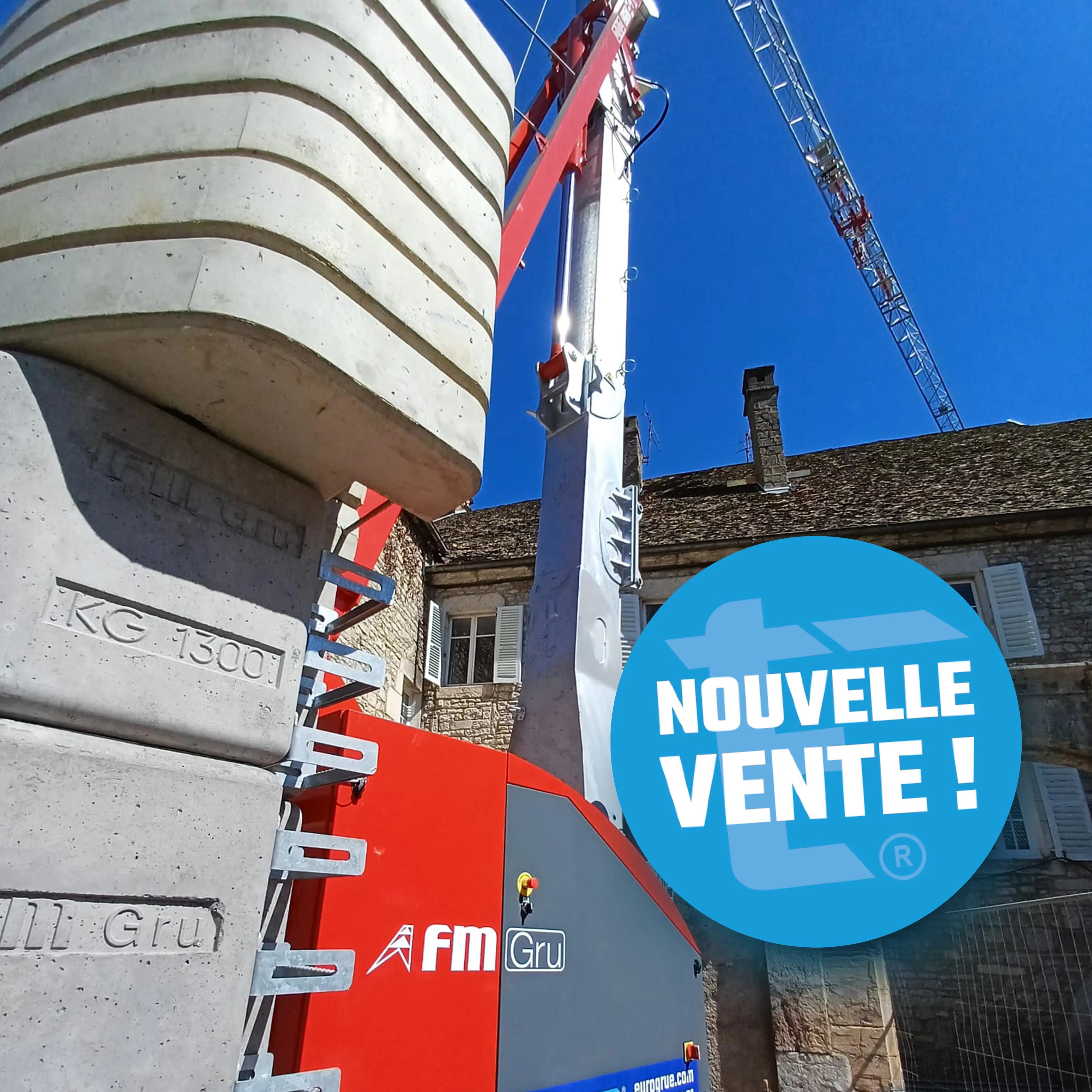 Photo de grue 828 RBI installée en centre historique d'Ornans : détail des lests béton 1 300 kg et du mât rouge FMGRU — Eurogrue Ornans Franche-Comté